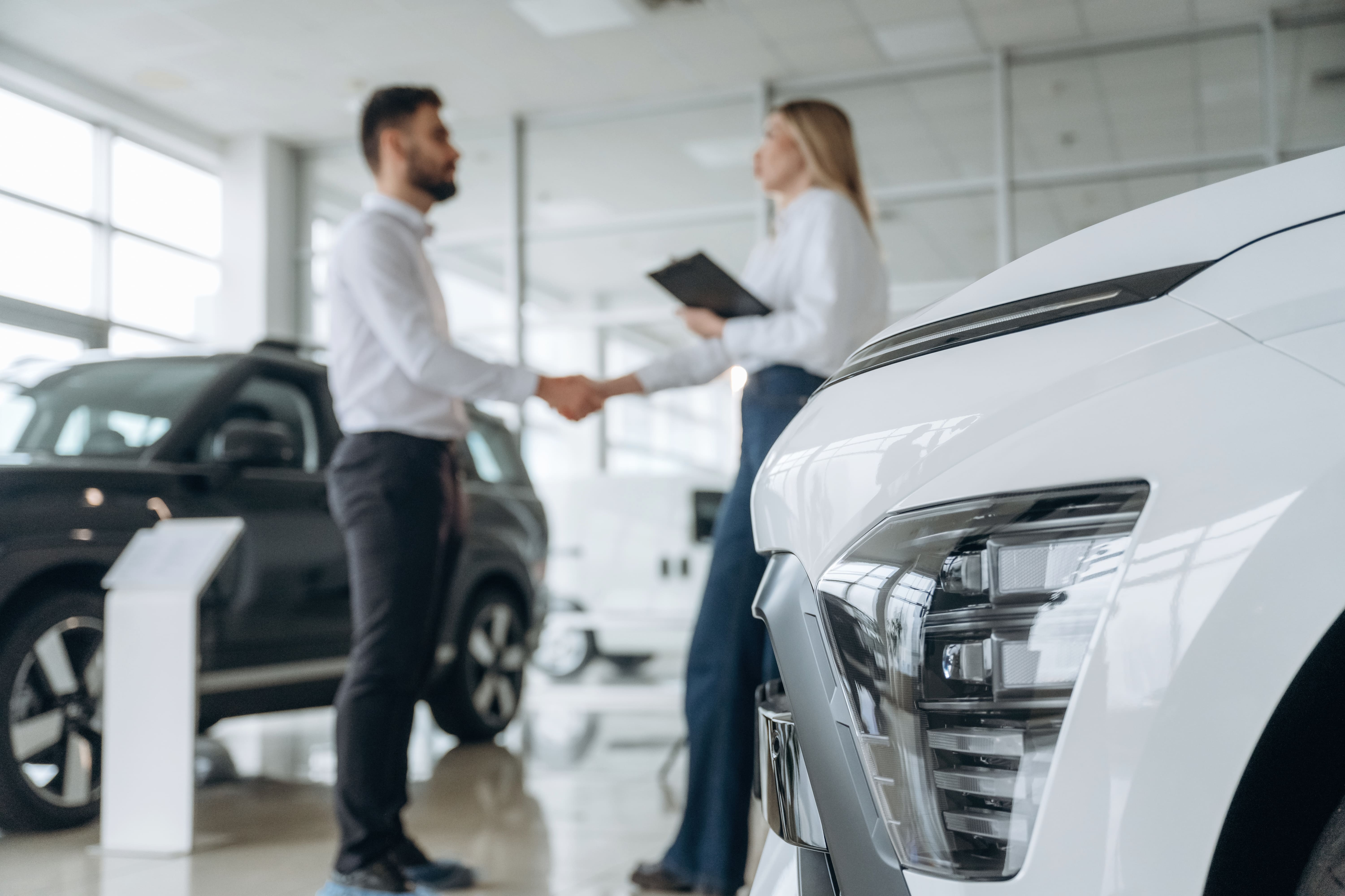 Exposición de coches de ocasión con compradores interesados, mostrando tendencias actuales en compra venta de coches